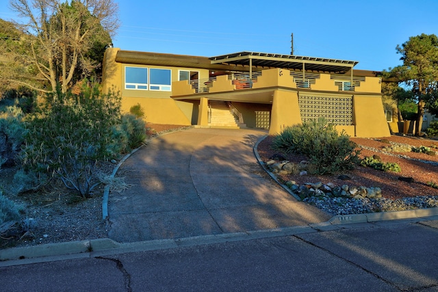 1106 Warm Sands Dr SE, Albuquerque, NM 87123 - view of front of house featuring stucco siding, driveway, a carport, and a balcony