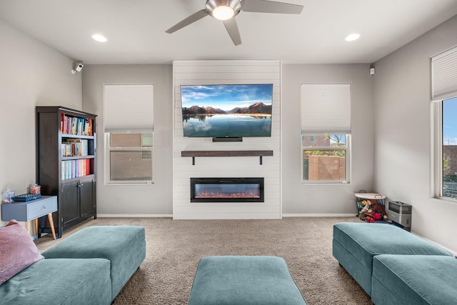 carpeted living area featuring a ceiling fan, recessed lighting, a large fireplace, and baseboards