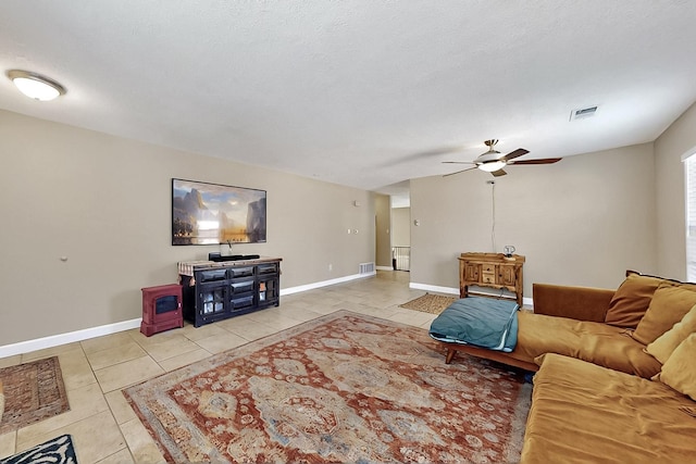 5727 Cibola Dr NE, Rio Rancho, NM 87144 - living room featuring a wood stove, light tile patterned floors, and a ceiling fan