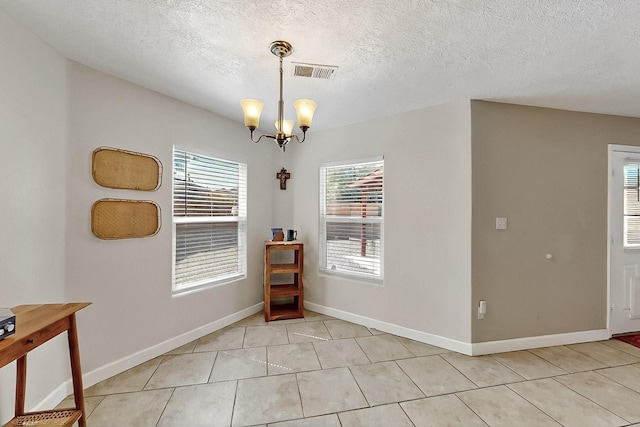 5727 Cibola Dr NE, Rio Rancho, NM 87144 - dining space featuring a chandelier, light tile patterned floors, and a textured ceiling