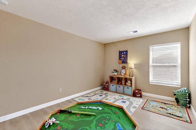 5727 Cibola Dr NE, Rio Rancho, NM 87144 - rec room featuring wood finished floors and a textured ceiling