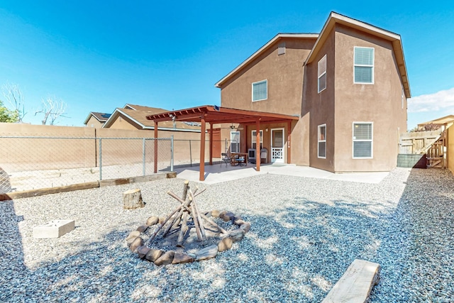 5727 Cibola Dr NE, Rio Rancho, NM 87144 - rear view of house featuring stucco siding, a fire pit, a fenced backyard, and a patio