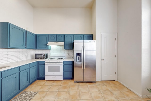 10216 Sand Sage Dr NW, Albuquerque, NM 87114 - kitchen with stainless steel refrigerator with ice dispenser, white range with gas stovetop, under cabinet range hood, blue cabinetry, and backsplash