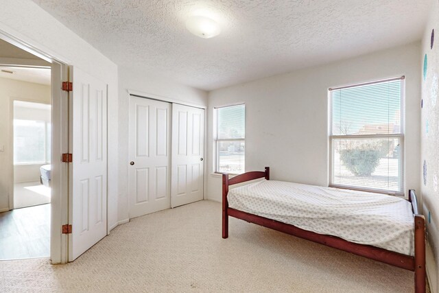 10216 Sand Sage Dr NW, Albuquerque, NM 87114 - bedroom featuring carpet, a textured ceiling, and a closet