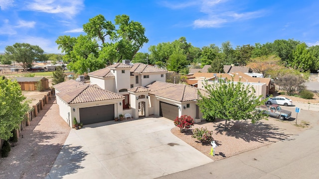 2815 Linda Pl SW, Albuquerque, NM 87105 - mediterranean / spanish house with an attached garage, stucco siding, a tile roof, concrete driveway, and a residential view