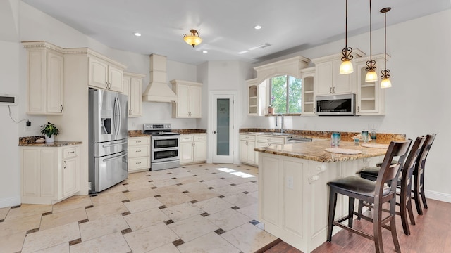 2815 Linda Pl SW, Albuquerque, NM 87105 - kitchen featuring appliances with stainless steel finishes, custom range hood, a peninsula, cream cabinetry, and a sink