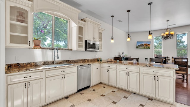 2815 Linda Pl SW, Albuquerque, NM 87105 - kitchen with stainless steel appliances, a sink, a peninsula, glass insert cabinets, and a chandelier