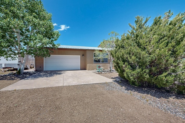 21 Camino No Mas, Stanley, NM 87056 - view of front of house with driveway, stucco siding, and a garage