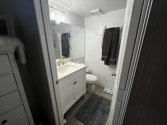 3301 Monroe St NE Unit D45, Albuquerque, NM 87110 - bathroom featuring wood finished floors, toilet, vanity, and a shower with door