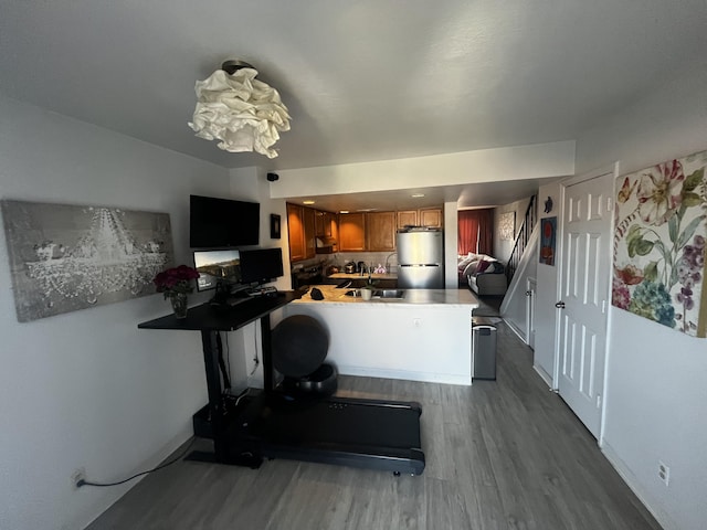 3301 Monroe St NE Unit D45, Albuquerque, NM 87110 - kitchen with freestanding refrigerator, brown cabinets, dark wood-type flooring, a peninsula, and baseboards