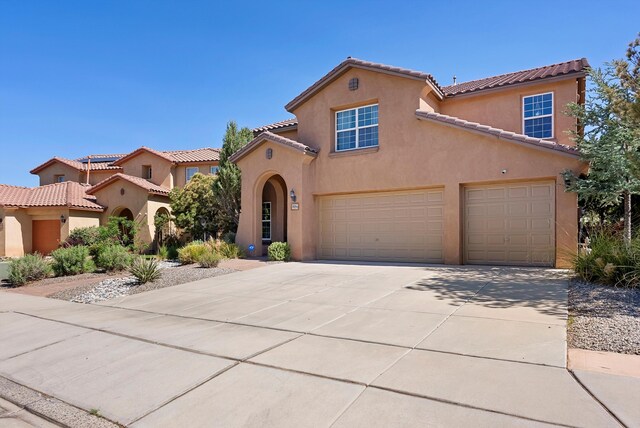 3515 Colina Serena Pl NE, Rio Rancho, NM 87124 - mediterranean / spanish-style home featuring stucco siding, concrete driveway, a tiled roof, and a garage