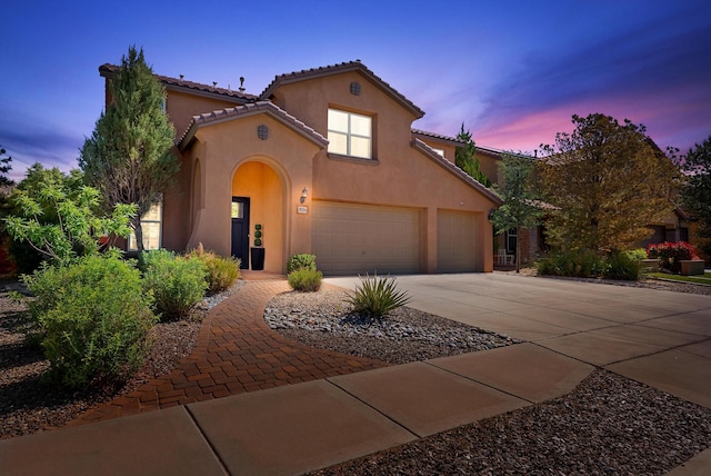 3515 Colina Serena Pl NE, Rio Rancho, NM 87124 - mediterranean / spanish home featuring concrete driveway, stucco siding, a tiled roof, and an attached garage