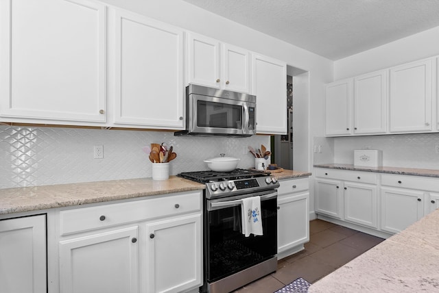 3515 Colina Serena Pl NE, Rio Rancho, NM 87124 - kitchen with stainless steel appliances, white cabinets, backsplash, and light stone countertops