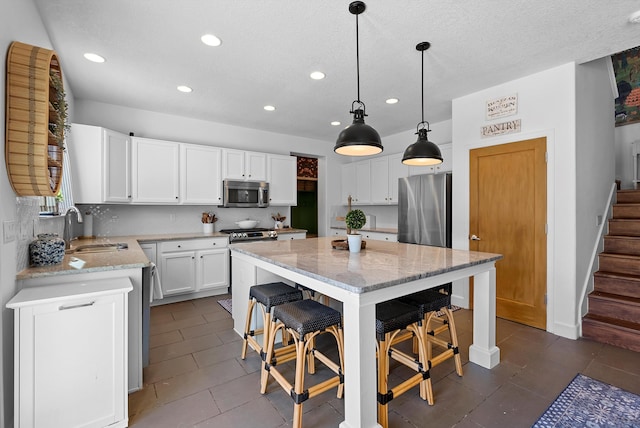 3515 Colina Serena Pl NE, Rio Rancho, NM 87124 - kitchen with appliances with stainless steel finishes, a sink, recessed lighting, light stone counters, and white cabinets