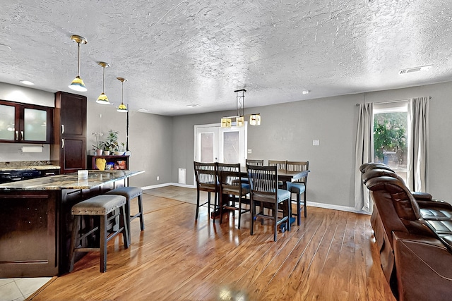 1905 Clearwater Loop NE, Rio Rancho, NM 87144 - dining space with light wood-style flooring, baseboards, and a textured ceiling