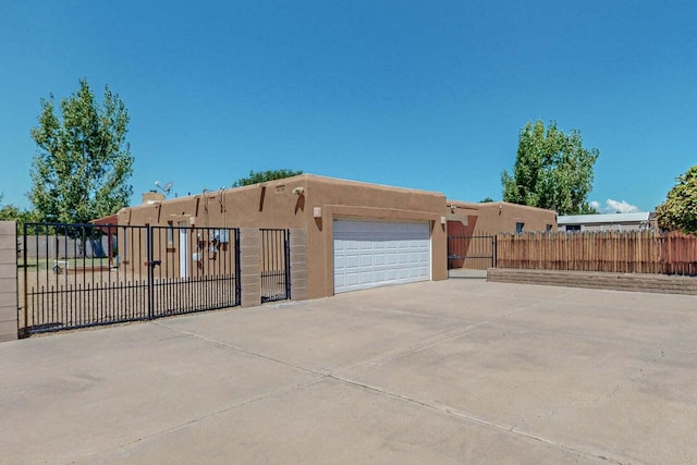 501 Calle De La Angel, Bernalillo, NM 87004 - view of front facade with stucco siding, a garage, and a gate