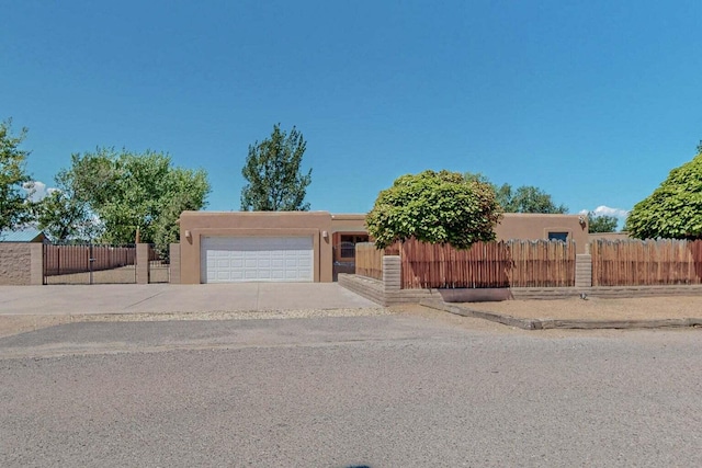 501 Calle De La Angel, Bernalillo, NM 87004 - adobe home featuring stucco siding, an attached garage, and concrete driveway
