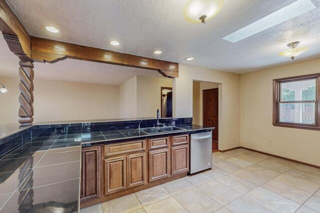 501 Calle De La Angel, Bernalillo, NM 87004 - kitchen with dishwasher, a sink, a textured ceiling, brown cabinets, and light tile patterned flooring
