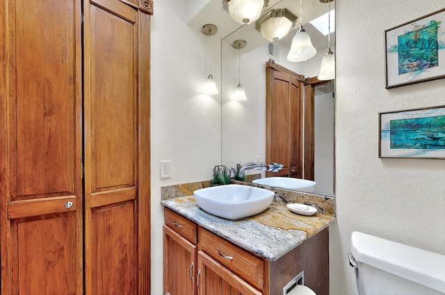 9737 Academy St NW, Albuquerque, NM 87114 - bathroom with toilet, vanity, and a textured wall