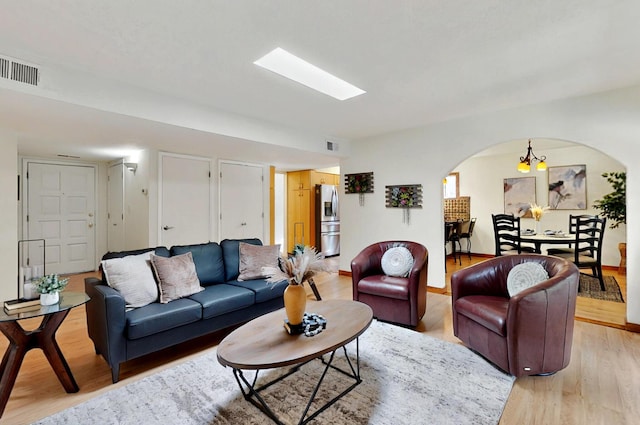 9737 Academy St NW, Albuquerque, NM 87114 - living room featuring arched walkways and light wood-style flooring