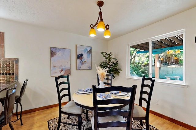 9737 Academy St NW, Albuquerque, NM 87114 - dining room with light wood finished floors, baseboards, and a chandelier