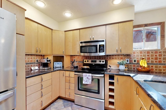 9737 Academy St NW, Albuquerque, NM 87114 - kitchen with stainless steel appliances, light brown cabinetry, dark stone counters, and backsplash