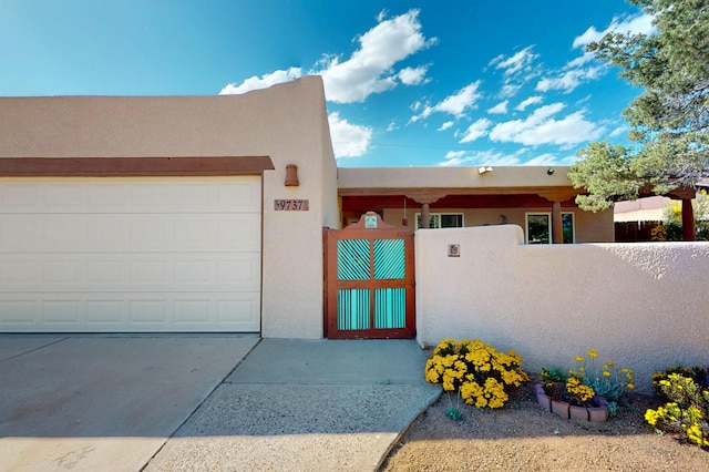 9737 Academy St NW, Albuquerque, NM 87114 - pueblo-style home featuring stucco siding, driveway, and a garage