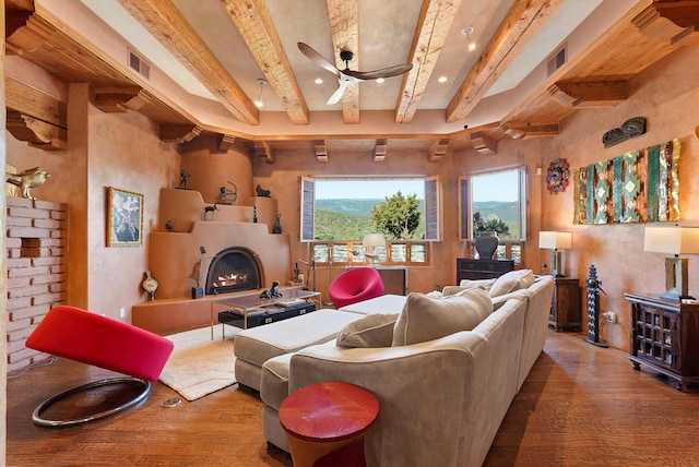 28 Canon Escondido, Sandia Park, NM 87047 - living room featuring hardwood / wood-style floors, beamed ceiling, a warm lit fireplace, a ceiling fan, and recessed lighting
