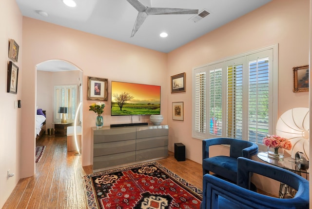 28 Canon Escondido, Sandia Park, NM 87047 - sitting room with arched walkways, wood finished floors, and recessed lighting