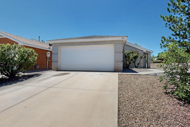 9927 Silverton Dr NW, Albuquerque, NM 87114 - view of front facade with stucco siding, a garage, and concrete driveway