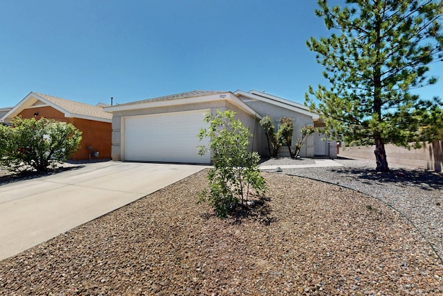 9927 Silverton Dr NW, Albuquerque, NM 87114 - view of front of house with a garage, stucco siding, and concrete driveway