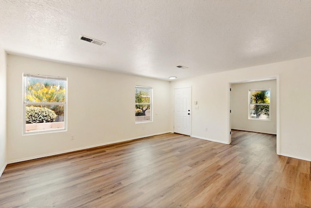 9927 Silverton Dr NW, Albuquerque, NM 87114 - empty room featuring light wood-type flooring, a textured ceiling, and baseboards