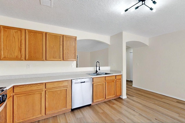 9927 Silverton Dr NW, Albuquerque, NM 87114 - kitchen featuring dishwasher, a sink, arched walkways, light wood-style flooring, and light countertops