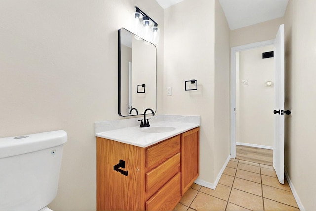 9927 Silverton Dr NW, Albuquerque, NM 87114 - half bath with tile patterned floors, vanity, toilet, and baseboards