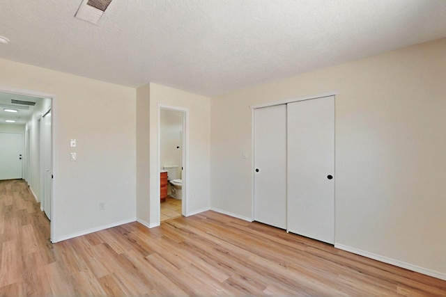 9927 Silverton Dr NW, Albuquerque, NM 87114 - unfurnished bedroom featuring light wood-type flooring, ensuite bath, a closet, and baseboards