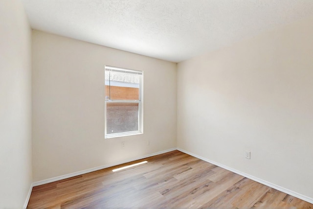 9927 Silverton Dr NW, Albuquerque, NM 87114 - spare room featuring wood finished floors, baseboards, and a textured ceiling