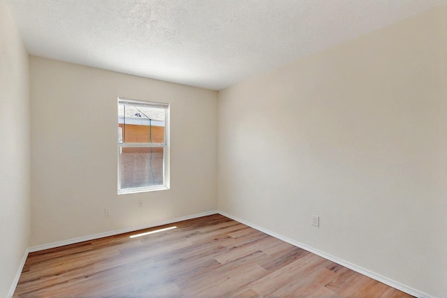 9927 Silverton Dr NW, Albuquerque, NM 87114 - unfurnished room featuring wood finished floors, baseboards, and a textured ceiling