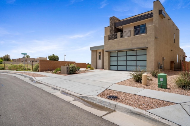 801 Horned Owl Dr NE, Albuquerque, NM 87122 - contemporary home with concrete driveway, a garage, a balcony, and stucco siding