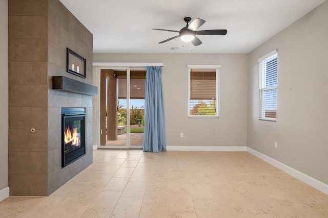 801 Horned Owl Dr NE, Albuquerque, NM 87122 - unfurnished living room with a tiled fireplace, ceiling fan, and baseboards