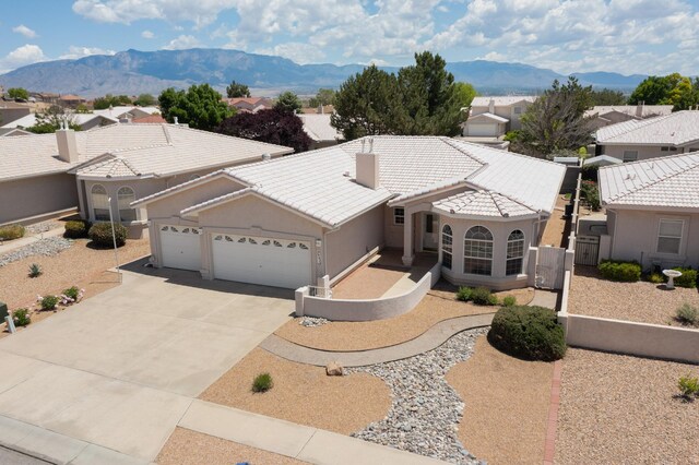 10320 Durham St NW, Albuquerque, NM 87114 - mediterranean / spanish-style house with a garage, a tile roof, driveway, a mountain view, and stucco siding