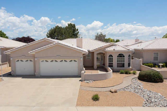 10320 Durham St NW, Albuquerque, NM 87114 - view of front facade featuring a tiled roof, driveway, an attached garage, and stucco siding
