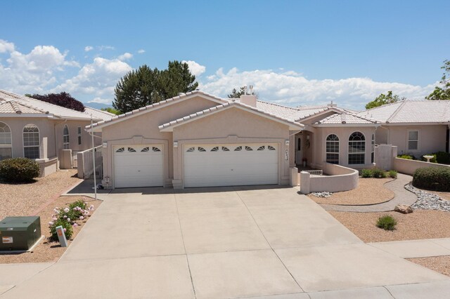 10320 Durham St NW, Albuquerque, NM 87114 - view of front facade featuring an attached garage, driveway, stucco siding, and a tile roof