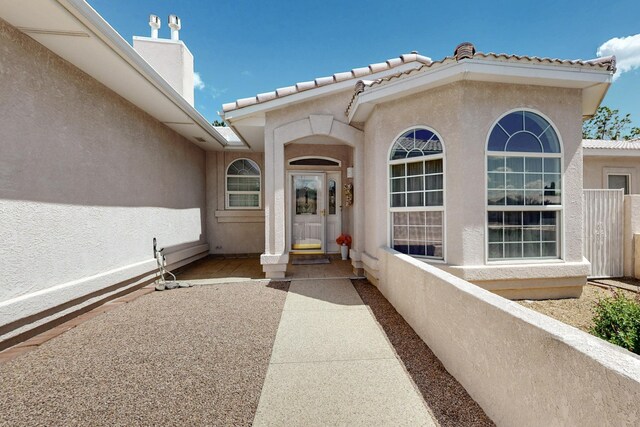 10320 Durham St NW, Albuquerque, NM 87114 - property entrance with stucco siding, a tile roof, and a chimney