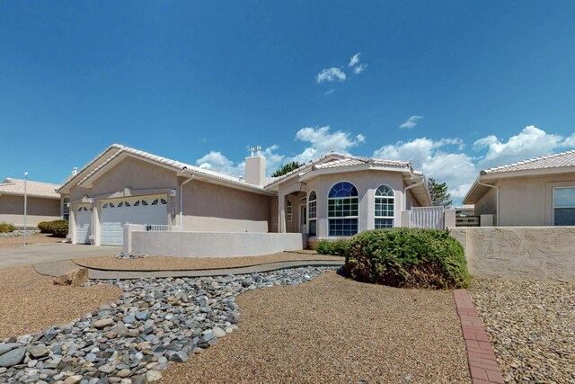 10320 Durham St NW, Albuquerque, NM 87114 - view of front of home featuring stucco siding, driveway, an attached garage, and a chimney