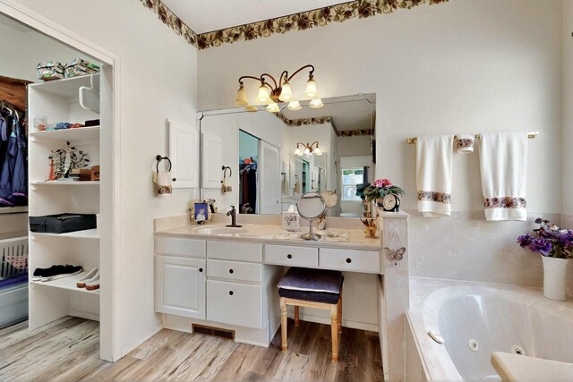 10320 Durham St NW, Albuquerque, NM 87114 - full bath with a whirlpool tub, a chandelier, wood finished floors, vanity, and a closet