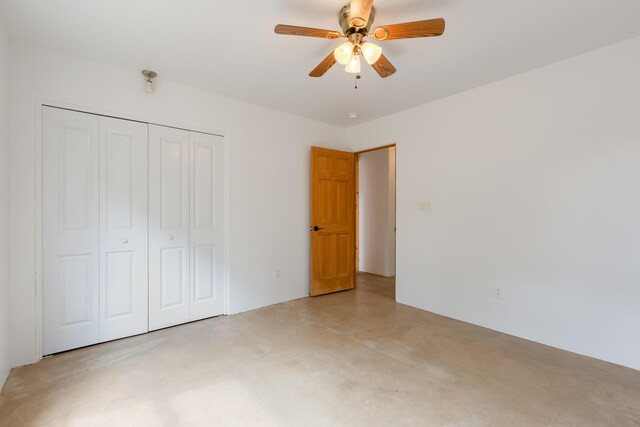 13 Asher Ln, Tijeras, NM 87059 - unfurnished bedroom featuring concrete flooring, a closet, and a ceiling fan