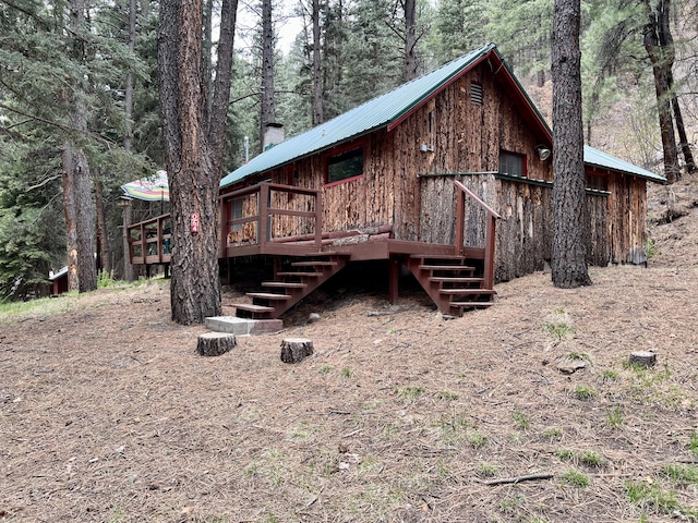 64 Argo Ln, Jemez Springs, NM 87025 - view of front of property with stairs, a deck, a view of trees, and metal roof