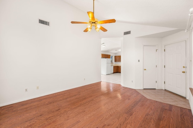 1905 Gomez Dr SW, Los Lunas, NM 87031 - unfurnished living room with vaulted ceiling, a ceiling fan, baseboards, and light wood-style flooring