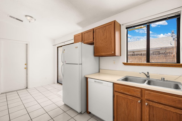 1905 Gomez Dr SW, Los Lunas, NM 87031 - kitchen featuring white appliances, a sink, brown cabinets, light countertops, and light tile patterned floors