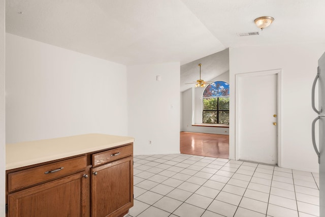 1905 Gomez Dr SW, Los Lunas, NM 87031 - kitchen with vaulted ceiling, light countertops, a ceiling fan, brown cabinetry, and freestanding refrigerator